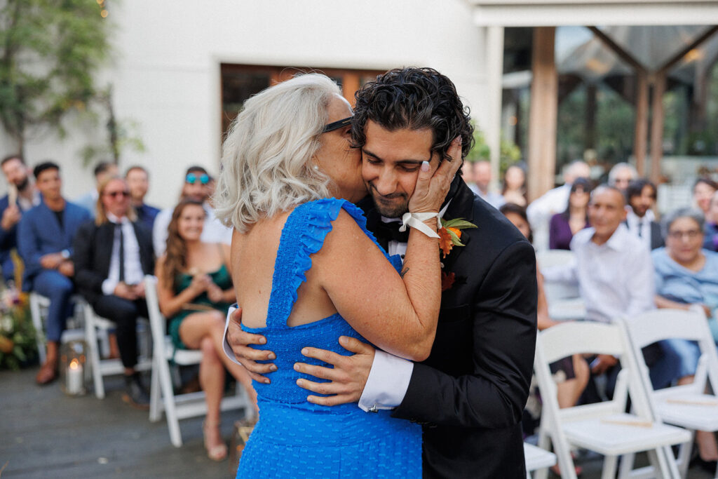 groom Noah James and his mother embrace before his wedding ceremony