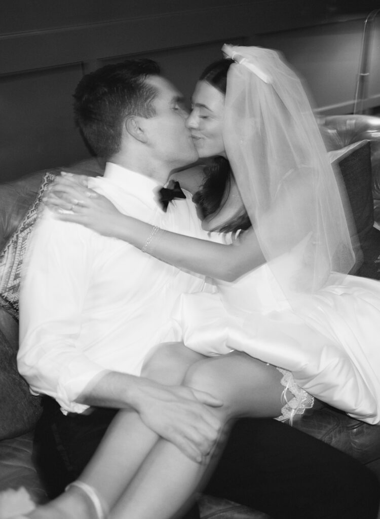 black and white film photo of bride and groom kissing