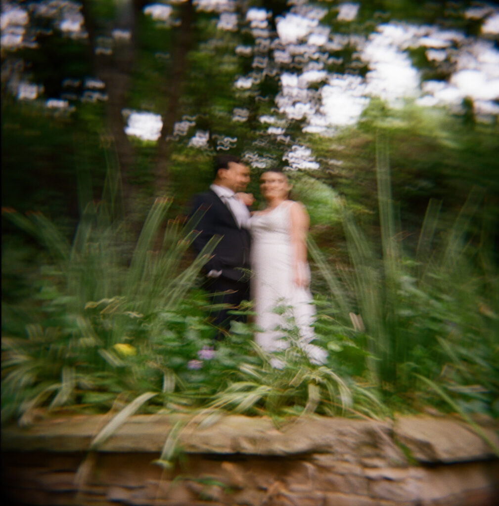 couple in the tall grass in backyard before wedding