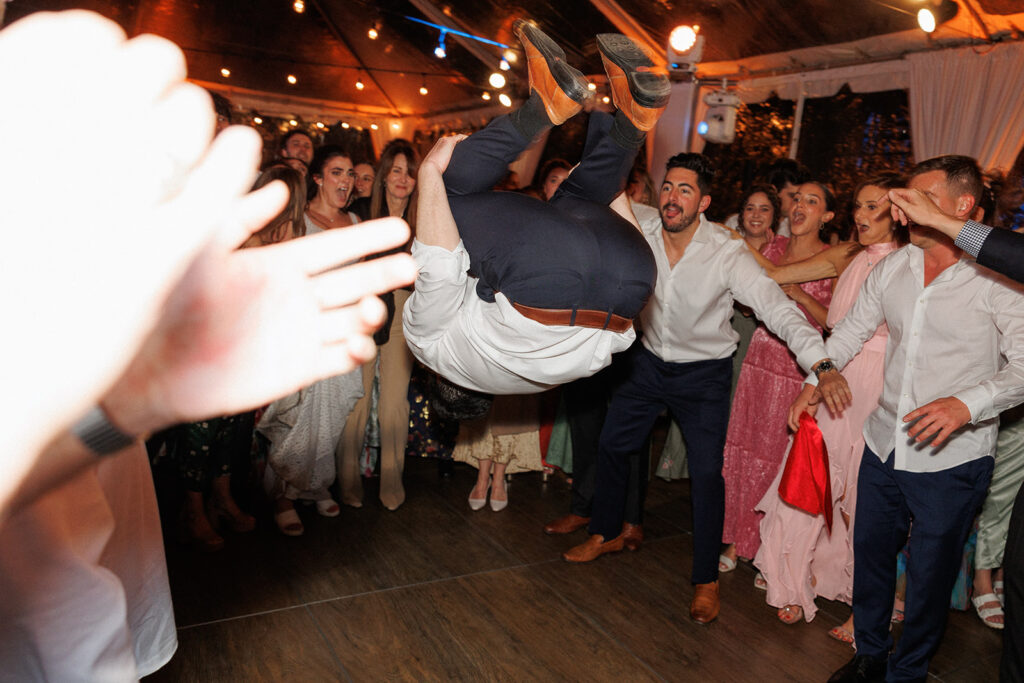 groom doing a backflip on the dance floor