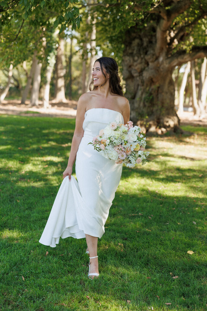 bride walking around the property outside with her floral bouquet 