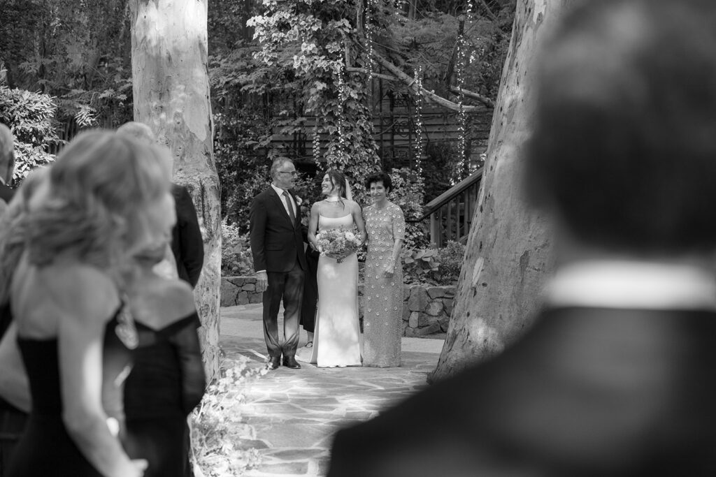 bride smiles at her dad right before her parents walk her down the aisle for her Birchwood Room wedding ceremony