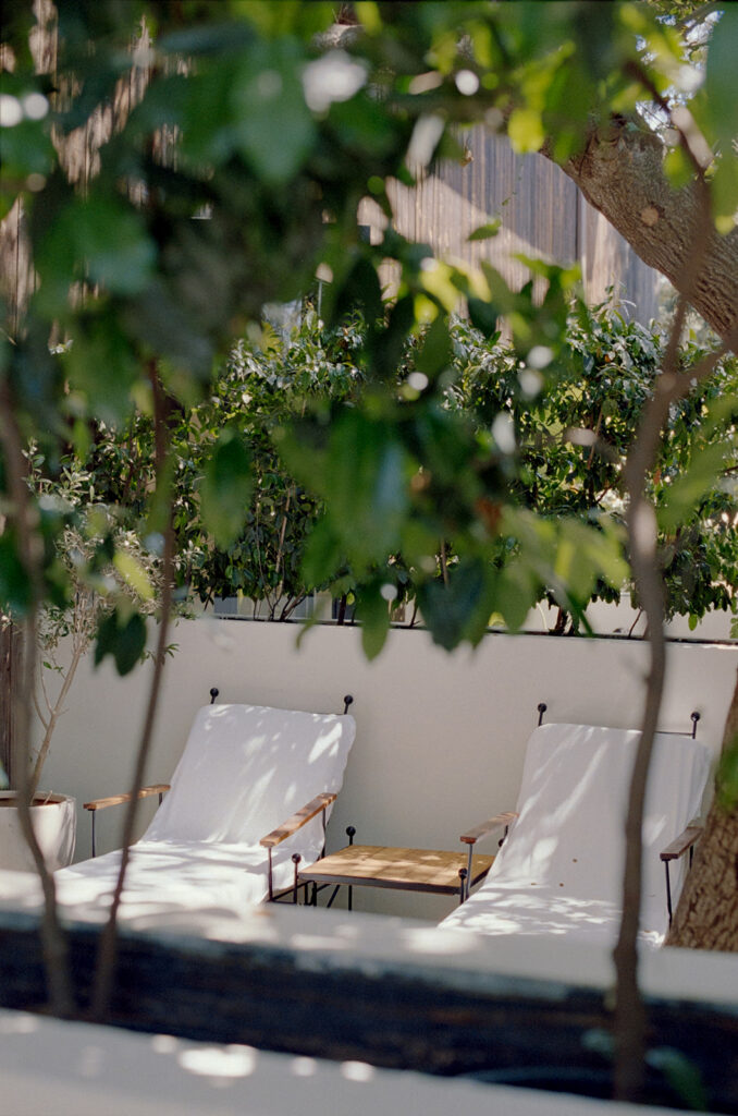 white lounge chairs seen through the foliage on the private deck of one of the Calamigos Ranch guest suites